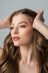 Naklejka premium Beauty, skincare, haircare advertising conception: close up studio portrait of beautiful young woman with healthy glow skin, long natural hair, nude colors makeup