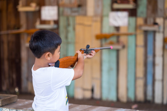 The boy is playing firing airsoft gun make from wooden