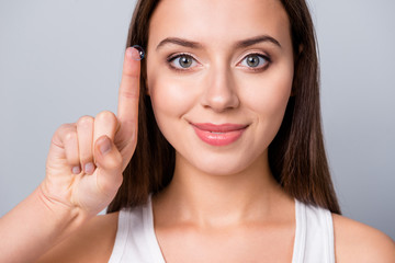 Naklejka premium Cropped close-up portrait of her she nice attractive lovely cute sweet dreamy cheerful brown-haired girl holding on finger transparent eye lens isolated over grey pastel color background