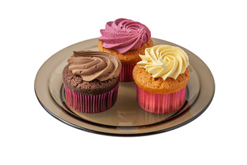 different cupcakes on a brown glass plate isolated on white