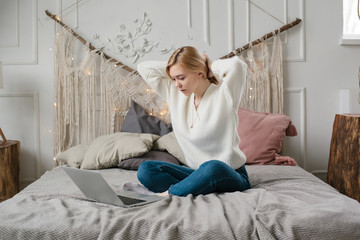 Girl student study online with skype teacher, happy young woman look at laptop sit on bed at home.