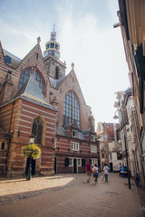 Gouda, Netherlands - June 29, 2019: Streets and buildings of the city of Gouda in Summer with tourists and people strolling