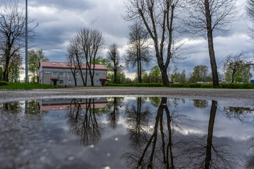 Street view with water reflection after rain in Estonia. Summer Rain Showers, urban view. Old...