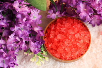 Fototapeta na wymiar Red sea salt and purple flowers, top view. Beauty and skin care.