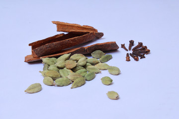 cinnamon,cloves,cardamom and black pepper on white background