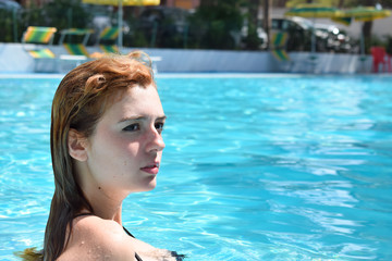 No make up Girl with yellow-orange wet hair in the pool