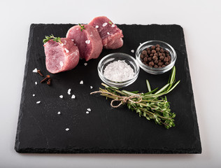 Fototapeta na wymiar fresh veal tenderloin with spices on a blackboard. veal. meat