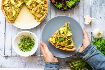 Vegetable casserole or tart with potato and zucchini. Vegan healthy food. Woman hands