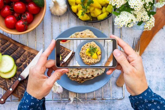 Make picture of vegan food with phone. Smartphone blogging photography of potato roti bread or tortilla corn flatbread.