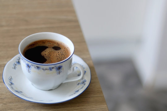 Black coffee in a vintage porcelain cup. Selective focus.