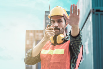 Caucasian foreman wearing helmet and making hand to stop something