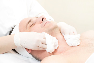 Fototapeta na wymiar Man in the mask cosmetic procedure in spa salon 