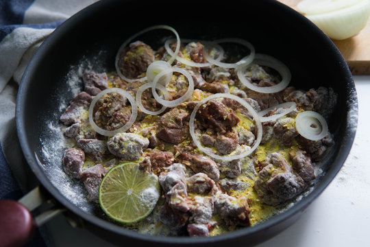 Chicken liver with onion rings in flour and lime with spices 