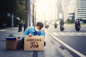 Stressed worker holds text of looking for a job