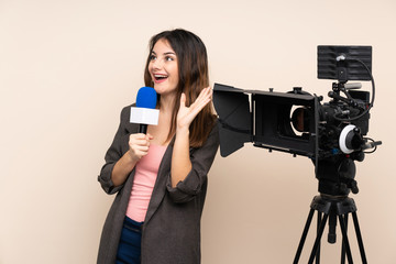 Reporter woman holding a microphone and reporting news over isolated background with surprise facial expression