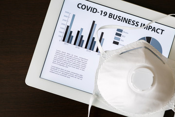 Business financial risk background concept. Office desk table with business charts in a digital tablet with white facemask