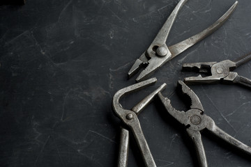old vintage pliers on a dark concrete background, close up, copy space