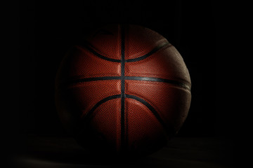 Basketball ball. Professional sport equipment isolated on black studio background. Concept of sport, leadership, competition, healthy lifestyle in motion and action, training. Close up, copyspace.