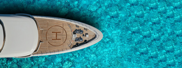 Aerial drone top view ultra wide photo of large yacht - boat with helicopter landing area anchored...