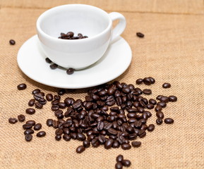 Cup of coffee with coffee beans on old background