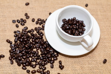 Cup of coffee with coffee beans on old background