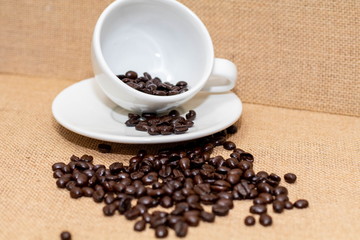 Cup of coffee with coffee beans on old background