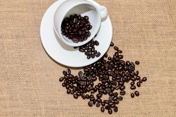 Cup of coffee with coffee beans on old background