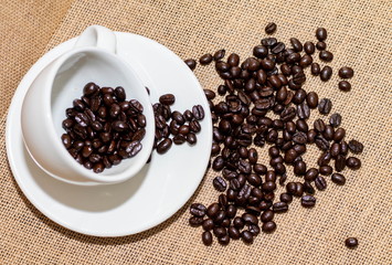 Cup of coffee with coffee beans on old background