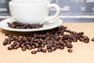 Cup of coffee with coffee beans on old background