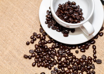 Cup of coffee with coffee beans on old background