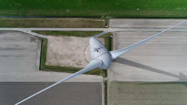 Aerial top down footage of a wind turbine or alternatively referred to as an energy converter is a device that converts the winds kinetic power into electricity which is a sustainable delivery