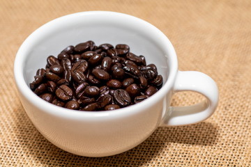 Cup of coffee with coffee beans on old background