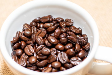 Cup of coffee with coffee beans on old background