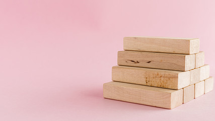 Wooden toy staircase on pink background for step to goal success concept