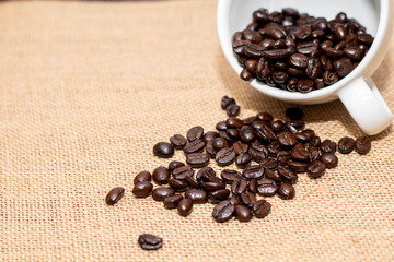 Cup of coffee with coffee beans on old background