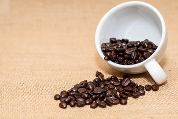 Fototapeta na wymiar Cup of coffee with coffee beans on old background