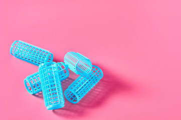 Heap of plastic cylindrical curler on pink desk in beauty salon. Care for hair. Fashion concept