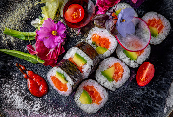 sushi roll with salmon, avocado, rice in plate