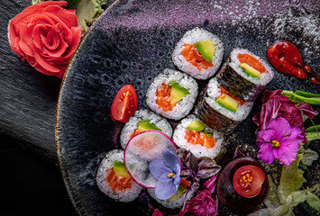 sushi roll with salmon, avocado, rice in plate