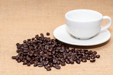 Cup of coffee with coffee beans on old background