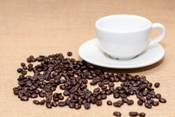Cup of coffee with coffee beans on old background