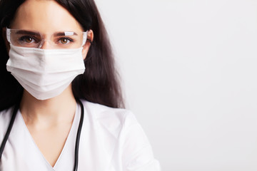 Doctor with protective goggles and stethoscope on her workspace