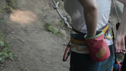 Girl wearing harness using chalk preparing for the climb at the rock