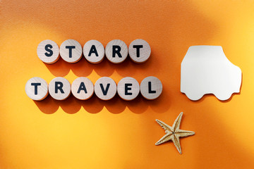 Start travel lettering, a blank sheet in the form of a car and starfish on an orange textured...