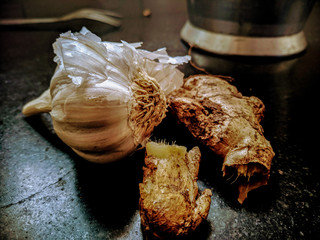 Close up of some ginger and raw garlic on kitchen floor