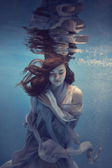 Portrait of a girl in a blue dress under water
