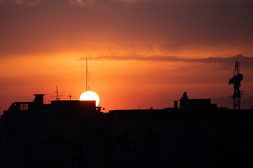 silhouettes of buildings in the light of the setting sun. Beautiful sunset in the city.