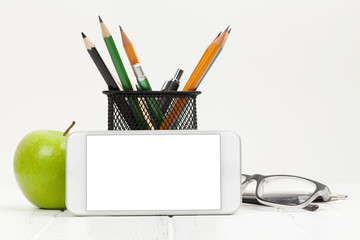 Naklejka premium Workplace with smartphone, supplies and apple