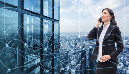 Businesswoman is calling with smartphone and network connection in the city