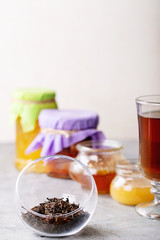 Glass cup of black tea served with honey